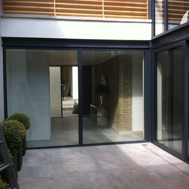 Floor-to-ceiling sliding doors opening to courtyard in Greenford