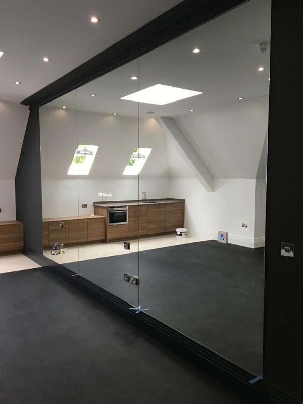 Frameless glass partition in loft conversion by Greenford glaziers