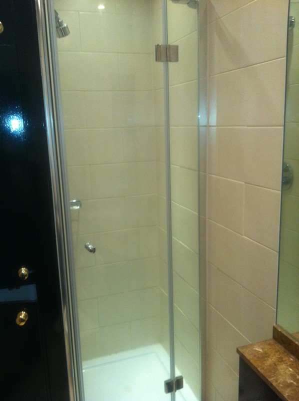 Frameless glass shower enclosure with chrome fittings in Greenford