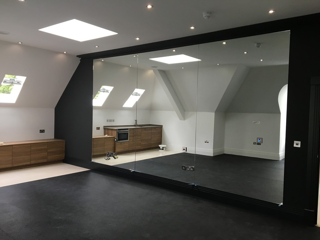 Frameless glass wall dividing loft conversion in Greenford
